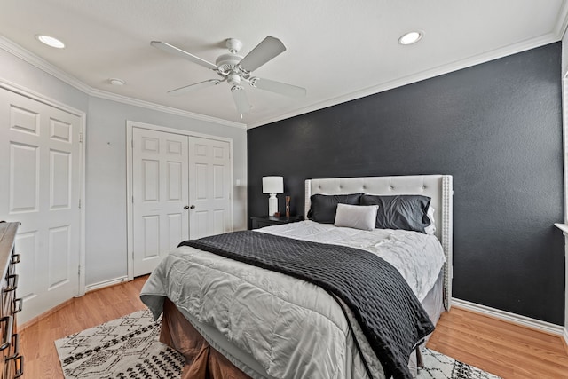 bedroom featuring crown molding, ceiling fan, light hardwood / wood-style floors, and a closet