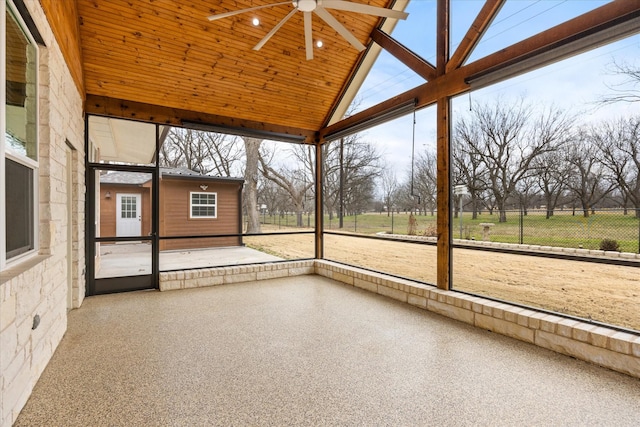 unfurnished sunroom featuring lofted ceiling, a wealth of natural light, wooden ceiling, and ceiling fan