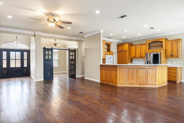 kitchen with ceiling fan, a barn door, dark wood-type flooring, and white appliances