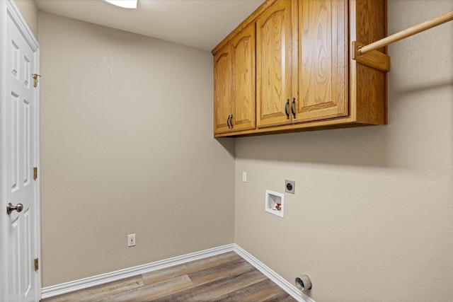 washroom with cabinets, wood-type flooring, hookup for an electric dryer, and hookup for a washing machine