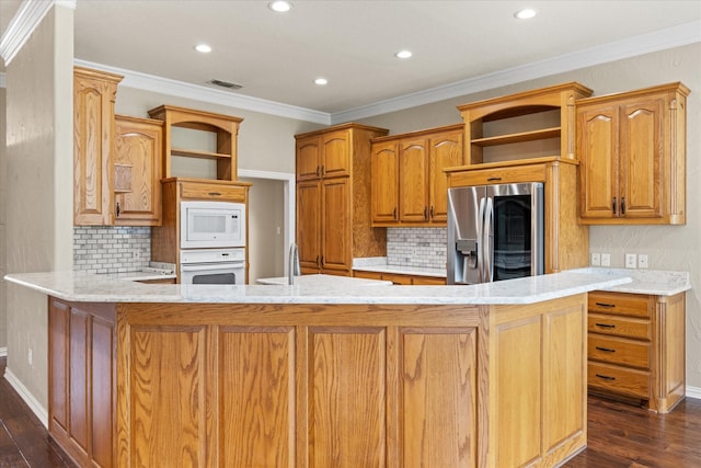 kitchen featuring white appliances, crown molding, light stone counters, dark hardwood / wood-style flooring, and kitchen peninsula