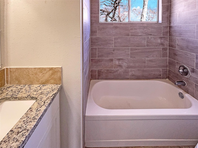 bathroom with vanity and a tub