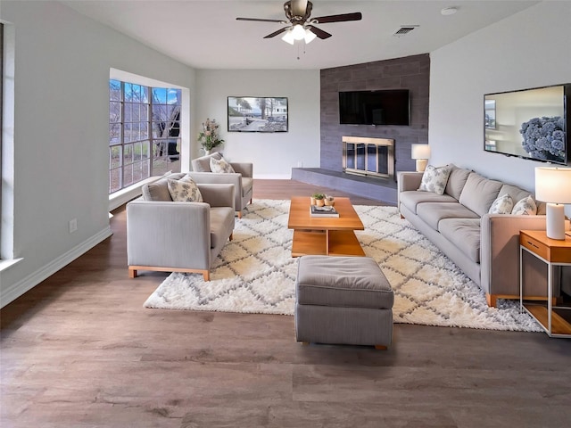 living room featuring a fireplace, dark hardwood / wood-style floors, and ceiling fan