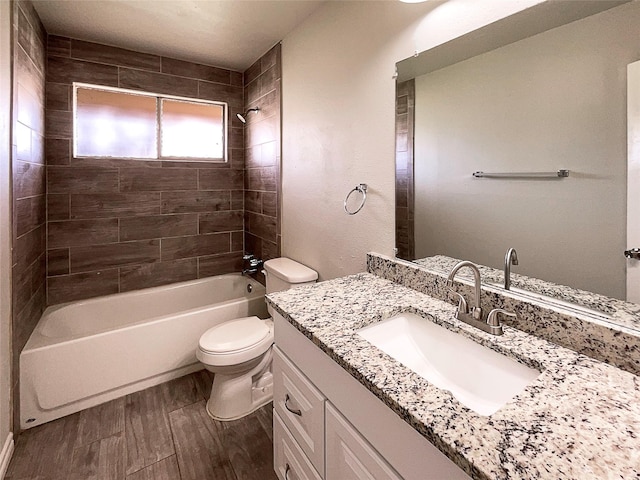 full bathroom with tiled shower / bath, hardwood / wood-style floors, vanity, and toilet