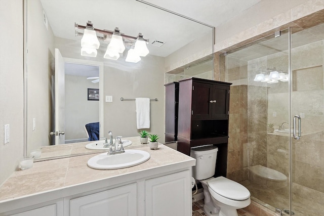 bathroom featuring vanity, toilet, and a shower with shower door