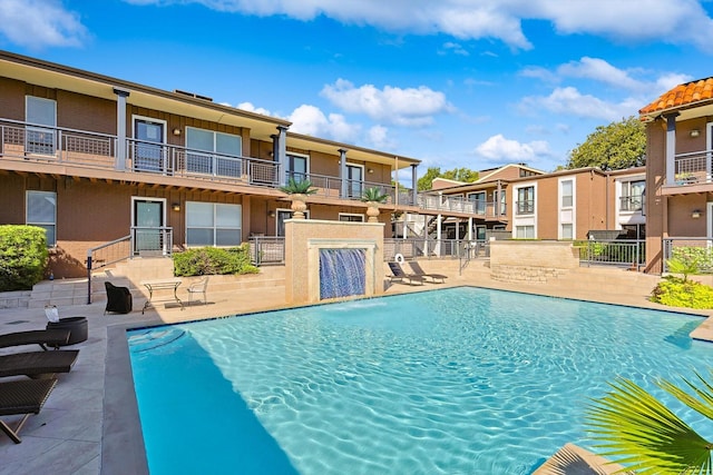 view of pool with pool water feature and a patio