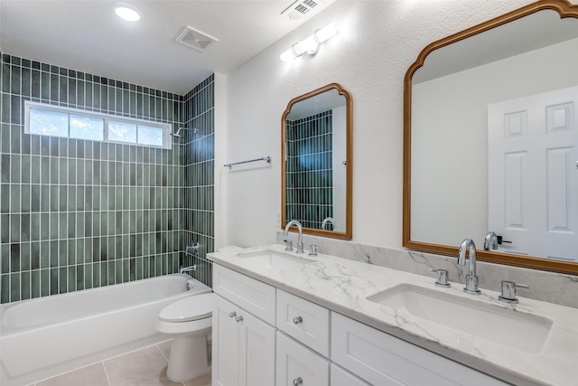 full bathroom with vanity, tiled shower / bath combo, tile patterned floors, and toilet