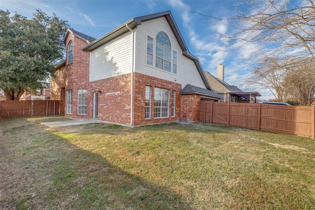 back of house with a yard and a patio