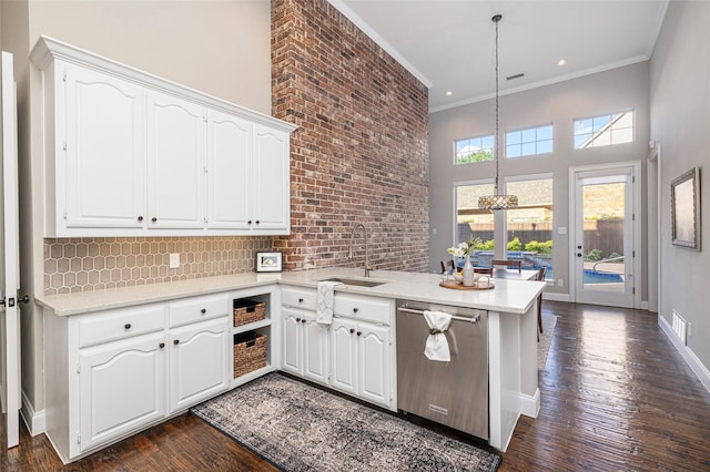 kitchen with sink, white cabinetry, hanging light fixtures, stainless steel dishwasher, and kitchen peninsula