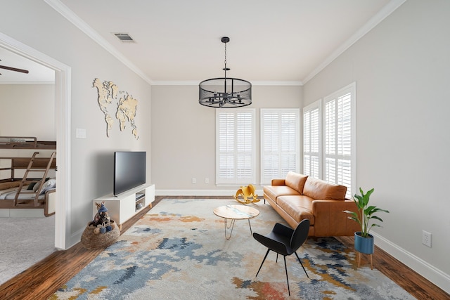 living room with crown molding, dark hardwood / wood-style flooring, and a chandelier