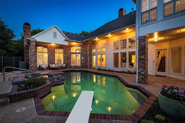 view of swimming pool featuring a diving board, central AC, and a patio area