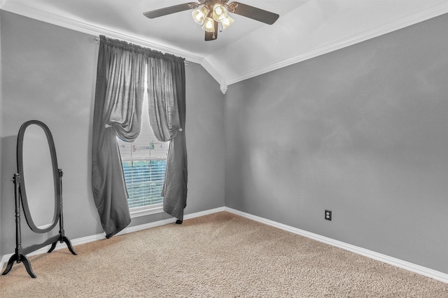 empty room featuring ceiling fan, lofted ceiling, carpet flooring, and ornamental molding