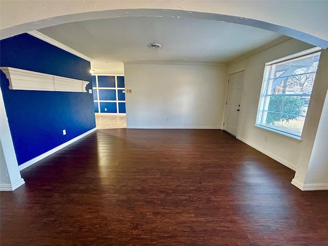 empty room with dark hardwood / wood-style flooring and ornamental molding