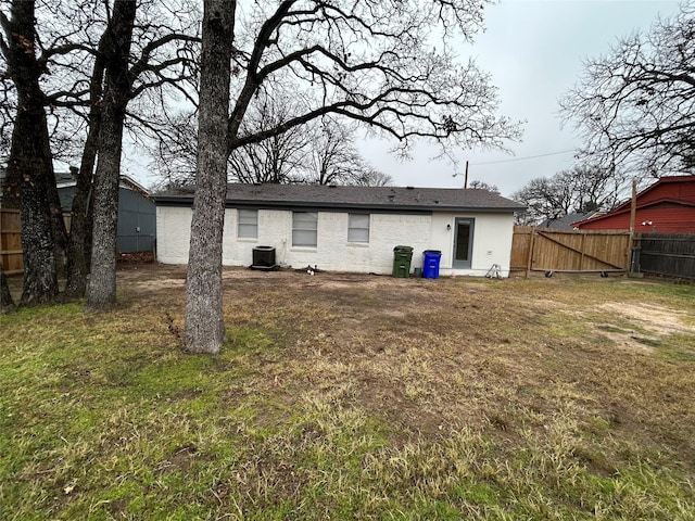 rear view of house with a yard and central AC unit