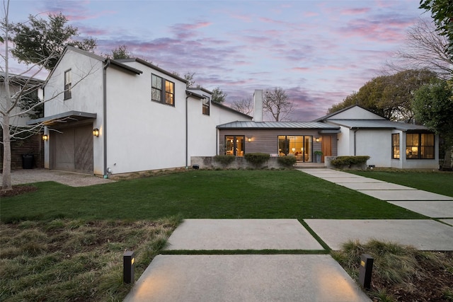 exterior space with a garage and a lawn