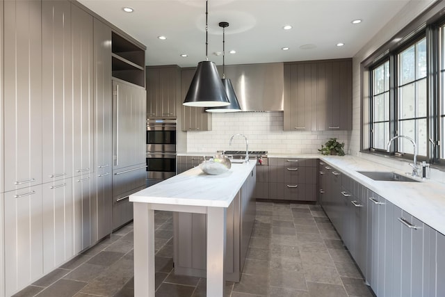 kitchen featuring sink, a center island, hanging light fixtures, stainless steel appliances, and backsplash