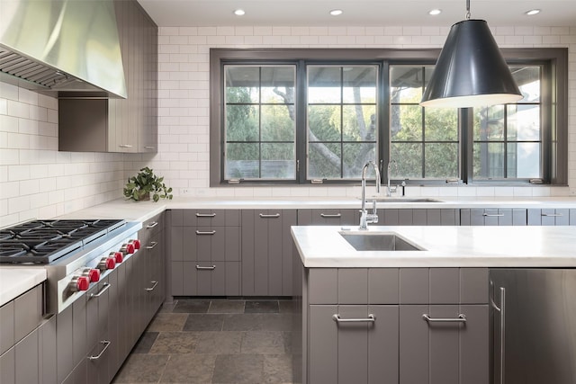 kitchen featuring gray cabinetry, extractor fan, a wealth of natural light, and stainless steel gas cooktop