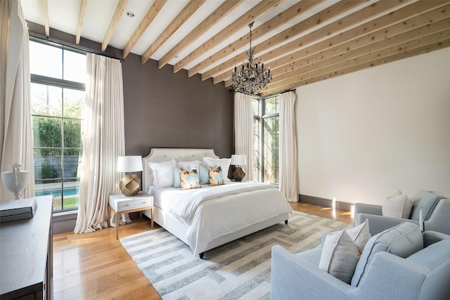 bedroom featuring a notable chandelier, beam ceiling, and hardwood / wood-style floors