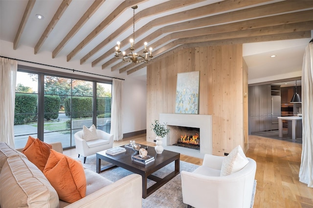 living room with light hardwood / wood-style flooring, lofted ceiling with beams, wooden walls, and a chandelier