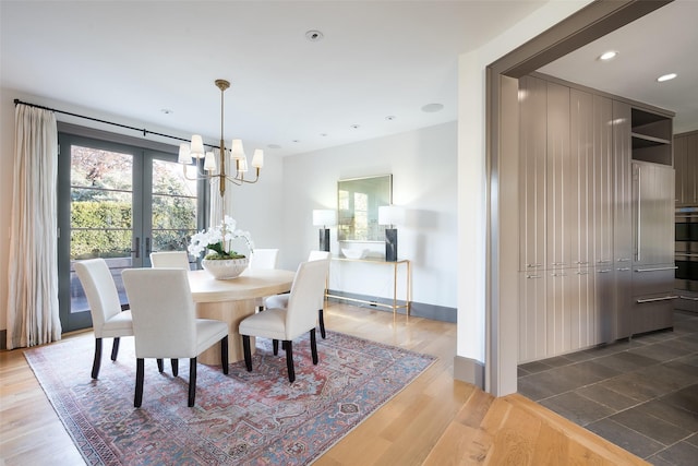 dining space featuring french doors, dark hardwood / wood-style flooring, and a chandelier