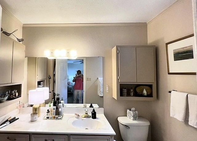 bathroom featuring vanity, crown molding, a textured ceiling, and toilet