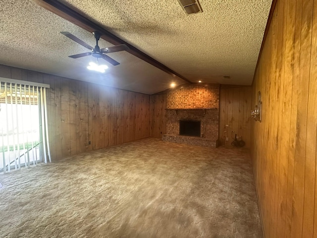 unfurnished living room with carpet floors, wooden walls, and a textured ceiling