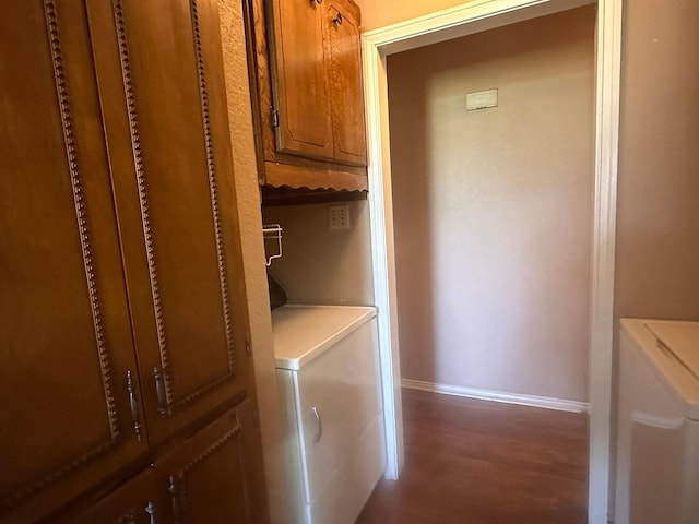 laundry area featuring baseboards, cabinet space, washing machine and dryer, and wood finished floors