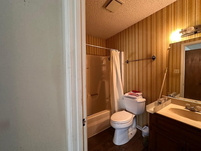 full bathroom with shower / bathtub combination with curtain, hardwood / wood-style flooring, vanity, a textured ceiling, and toilet