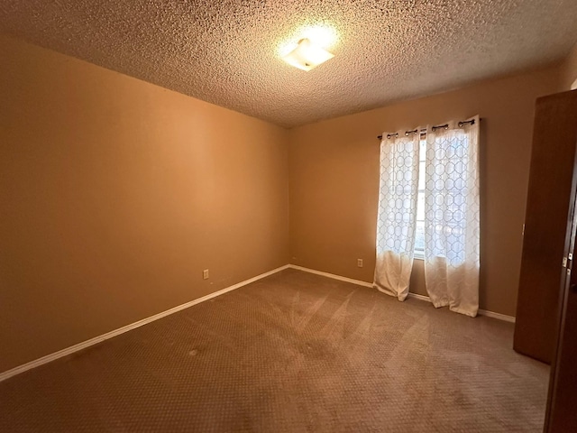 carpeted empty room with a textured ceiling