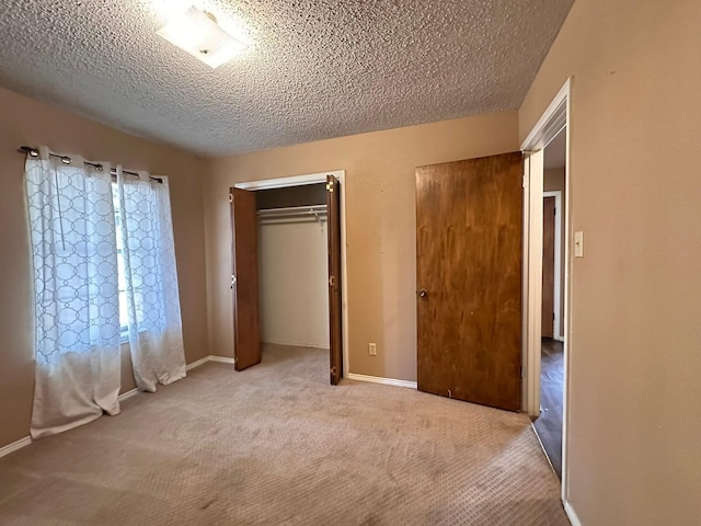 unfurnished bedroom with light carpet, a textured ceiling, and a closet