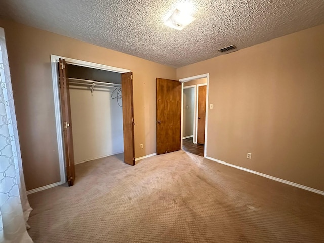 unfurnished bedroom with carpet, a textured ceiling, and a closet