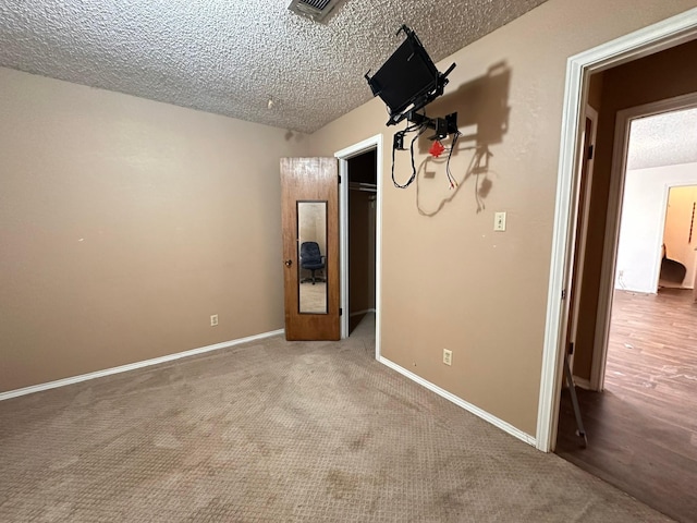 empty room featuring carpet and a textured ceiling