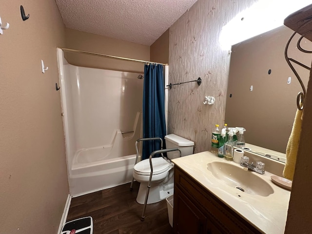 full bathroom featuring hardwood / wood-style floors, vanity, toilet, a textured ceiling, and shower / bath combo with shower curtain