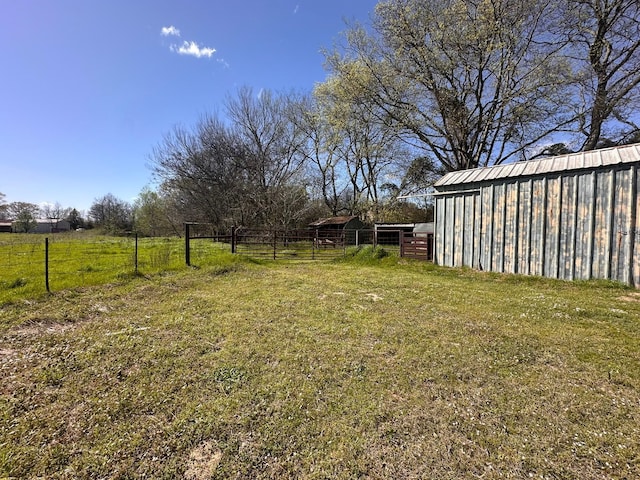 view of yard with an outbuilding, fence, and a pole building
