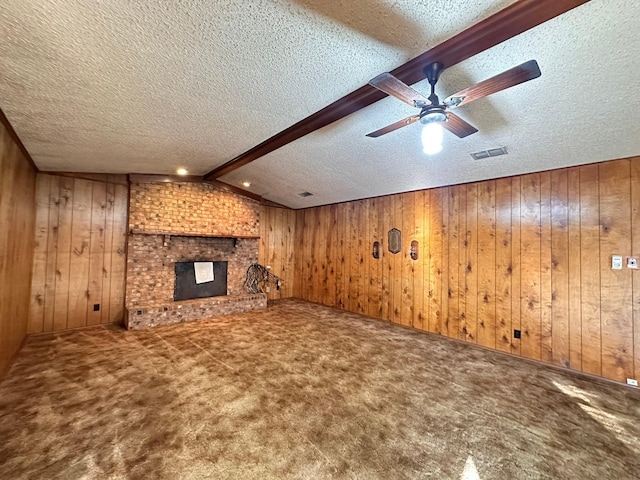 unfurnished living room featuring lofted ceiling with beams, carpet, wooden walls, and a fireplace