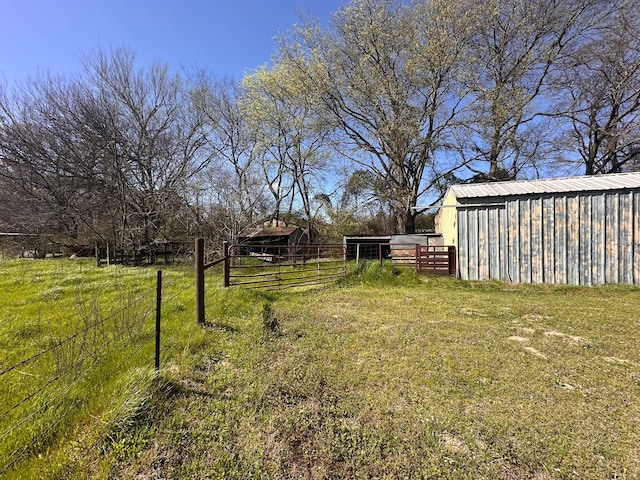 view of yard featuring an outbuilding, fence, and an outdoor structure