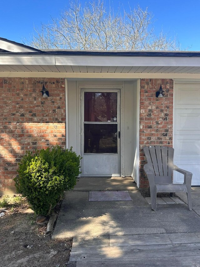 entrance to property featuring board and batten siding and brick siding