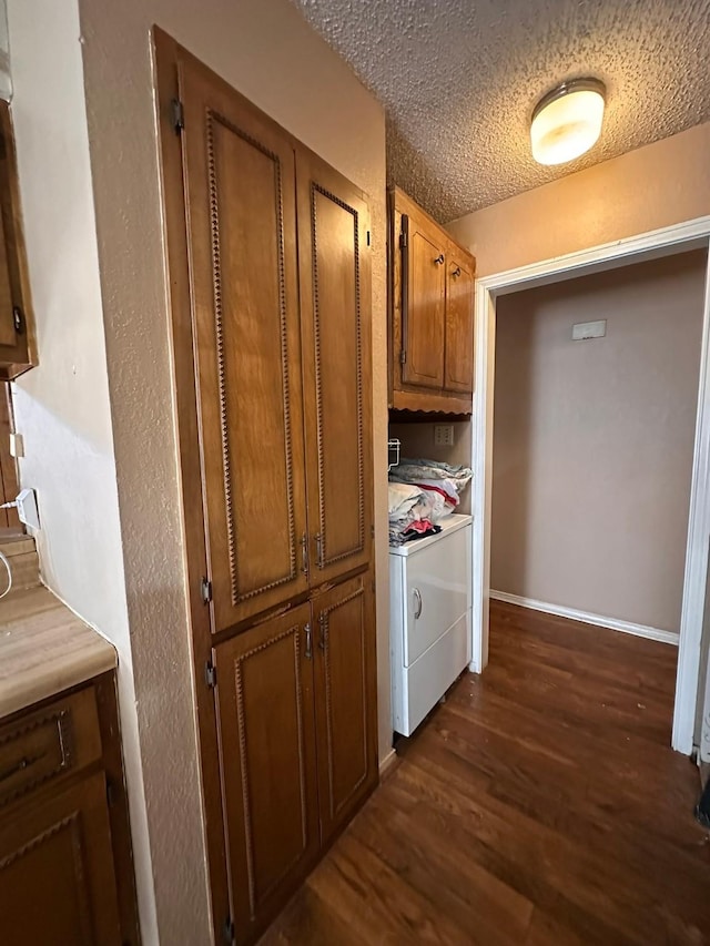 interior space featuring independent washer and dryer, dark hardwood / wood-style flooring, and a textured ceiling