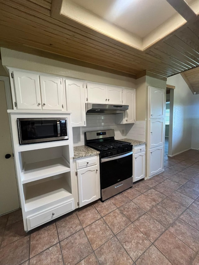 kitchen with white cabinetry, stainless steel appliances, light stone countertops, and backsplash