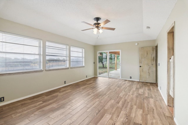 empty room with a textured ceiling, light hardwood / wood-style floors, and ceiling fan