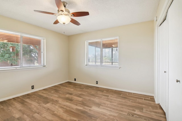 unfurnished bedroom with ceiling fan, a textured ceiling, light hardwood / wood-style floors, and a closet