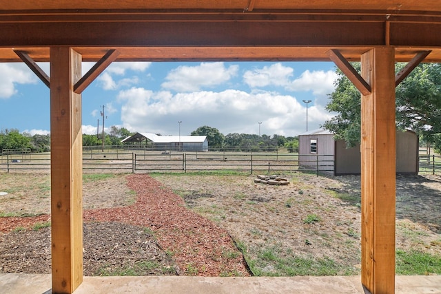 view of yard with an outdoor structure and a rural view