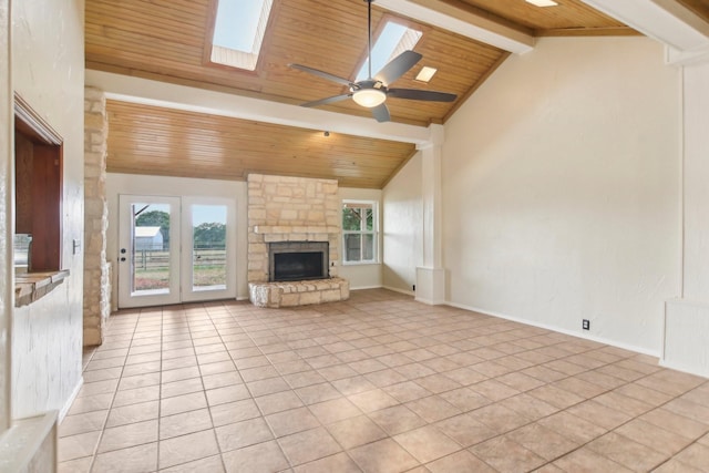 unfurnished living room with wood ceiling, a stone fireplace, light tile patterned floors, and a wealth of natural light