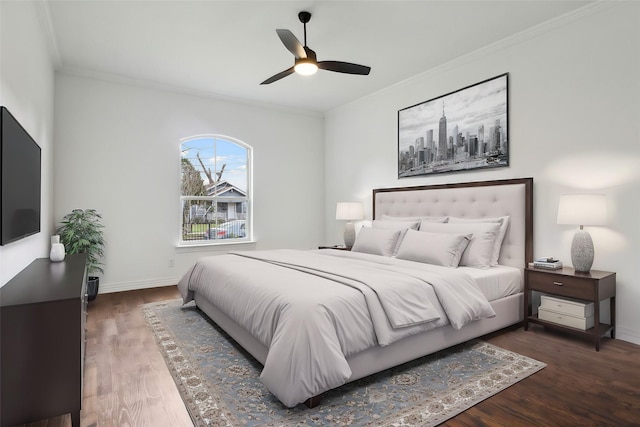 bedroom with ornamental molding, ceiling fan, baseboards, and wood finished floors