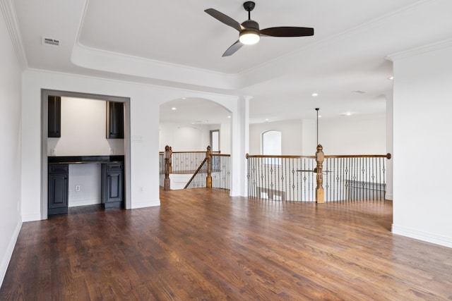 empty room with dark wood-style flooring, a raised ceiling, visible vents, and baseboards