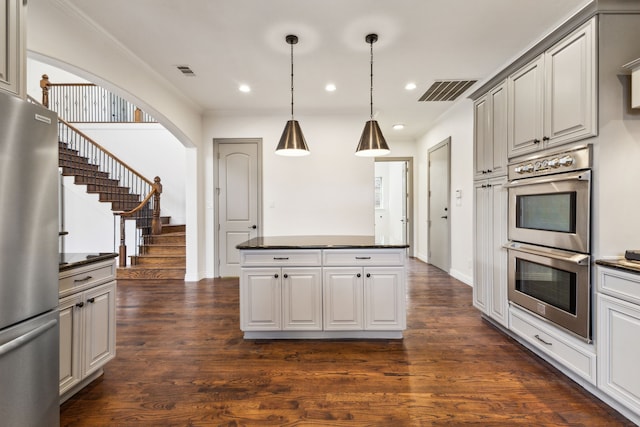 kitchen featuring dark wood finished floors, stainless steel appliances, dark countertops, recessed lighting, and visible vents