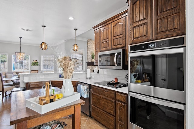 kitchen with light tile patterned flooring, appliances with stainless steel finishes, ornamental molding, and decorative light fixtures