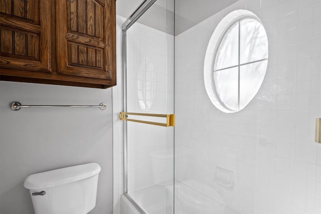 bathroom with shower / bath combination with glass door and toilet