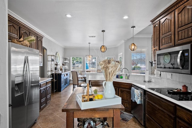 kitchen with pendant lighting, sink, dark brown cabinets, and stainless steel appliances