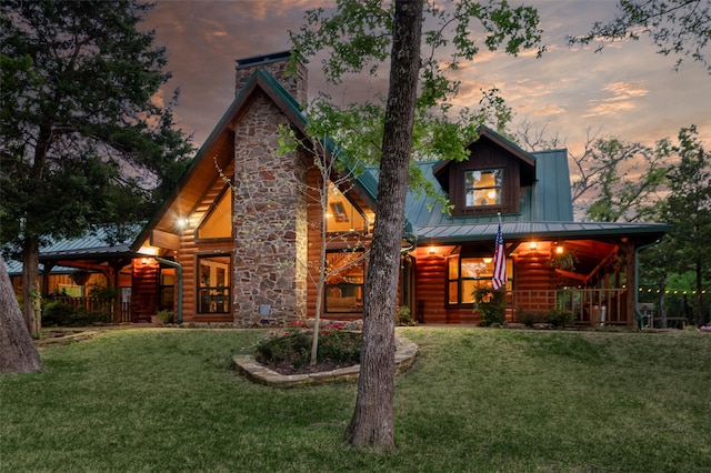 back house at dusk with a yard and covered porch